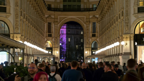 Milan, Italy – March 21, 2025: People walking through the Vittorio Emanuele II Gallery in the evening - Starpik Stock