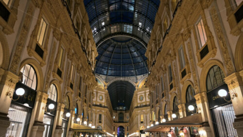 Milan, Italy – March 21, 2025: People walking through the Vittorio Emanuele II Gallery in the evening - Starpik Stock