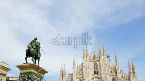 Milan, Italy – March 21, 2025: The Vittorio Emanuele II Statue in the Duomo Square with the gallery and the cathedral on the background in daylight - Starpik Stock