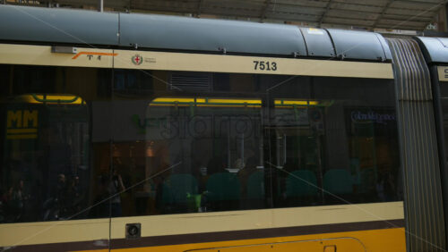 Milan, Italy – March 21, 2025: Yellow tram moving on the streets of the city in daylight - Starpik Stock
