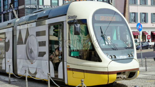 Milan, Italy – March 21, 2025: Yellow tram moving on the streets of the city in daylight - Starpik Stock