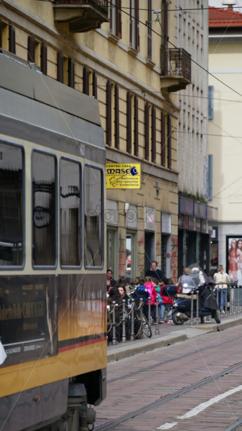 Milan, Italy – March 21, 2025: Yellow tram moving on the streets of the city in daylight. Vertical - Starpik Stock