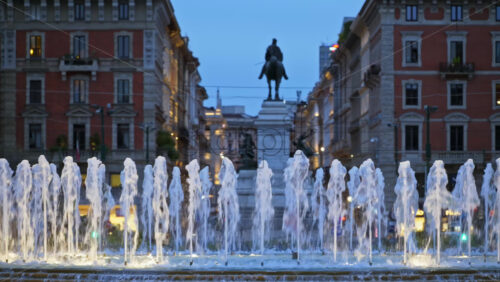 Milan, Italy – March 22, 2025: Close up of Piazza Castello Fountain with an equestrian statue on the background in the evening blue hour - Starpik Stock