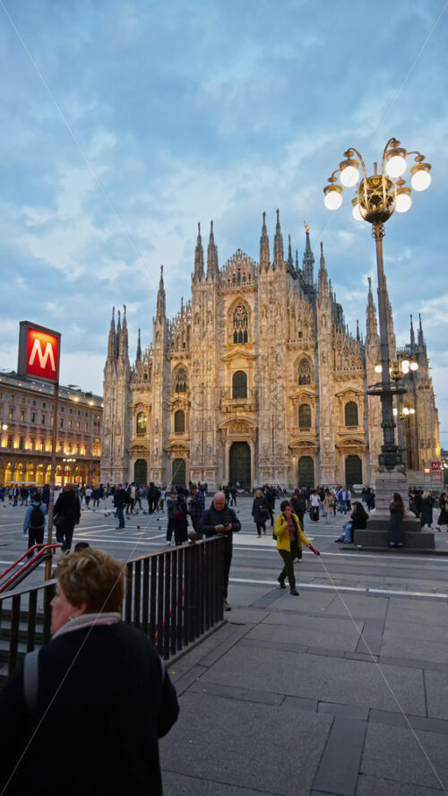 Milan, Italy – March 22, 2025: Multiple people walking through the Duomo Square in the evening. Vertical - Starpik Stock
