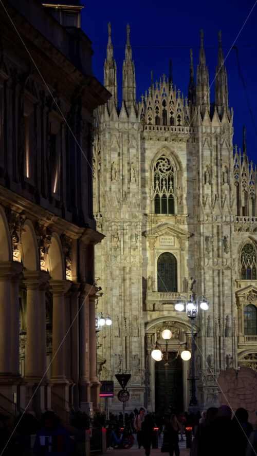 Milan, Italy – March 22, 2025: Multiple people walking through the Duomo Square in the evening. Vertical - Starpik Stock