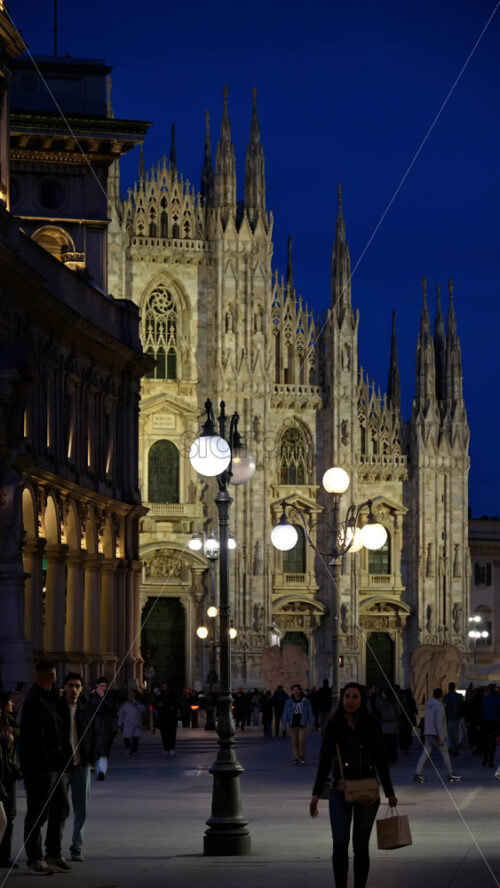 Milan, Italy – March 22, 2025: Multiple people walking through the Duomo Square in the evening. Vertical - Starpik Stock