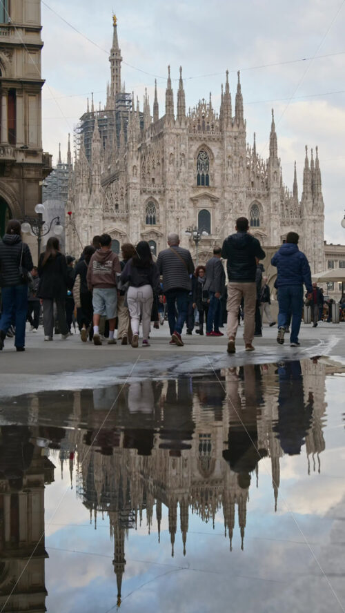 Milan, Italy – March 22, 2025: Multiple people walking through the Duomo Square on a rainy day. Vertical - Starpik Stock