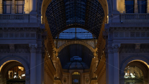 Milan, Italy – March 22, 2025: View of the Vittorio Emanuele II Gallery entrance from the Duomo square in the evening - Starpik Stock