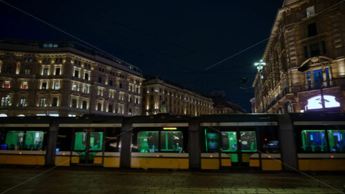 Milan, Italy – March 22, 2025: Yellow tram passing by on the street in the evening - Starpik Stock