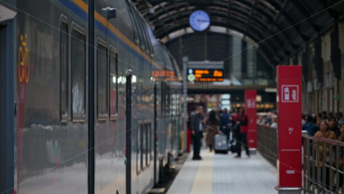 Milan, Italy – March 23, 2025: Blurred view of people walking at the train station near a train - Starpik Stock
