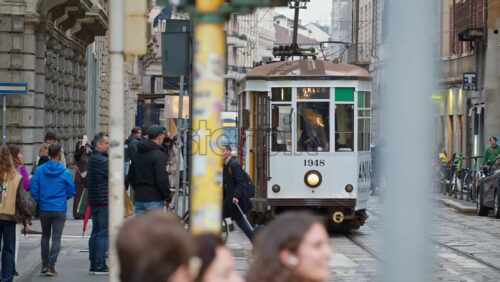 Milan, Italy – March 23, 2025: People and public transportation moving on the streets of the city in daylight - Starpik Stock