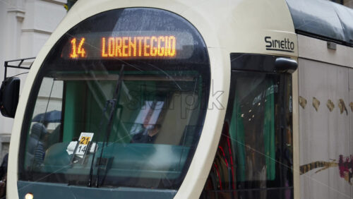 Milan, Italy – March 23, 2025: People and yellow tram moving on the streets of the city in the rain - Starpik Stock