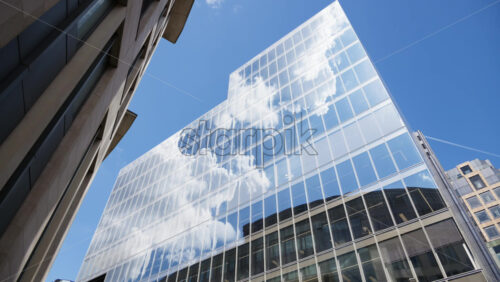 Modern glass skyscrapers of London’s financial district reflecting the blue sky next to historic architecture - Starpik Stock