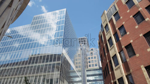 Modern glass skyscrapers of London’s financial district reflecting the blue sky next to historic architecture - Starpik Stock