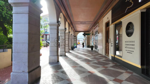 Monaco City, Monaco – July 18, 2025: People sitting at tables under a covered colonnade with arches in daylight - Starpik Stock
