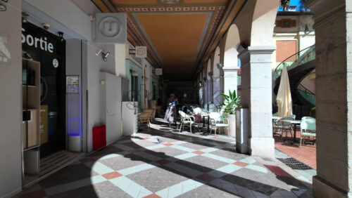 Monaco City, Monaco – July 18, 2025: People sitting at tables under a covered colonnade with arches in daylight - Starpik Stock