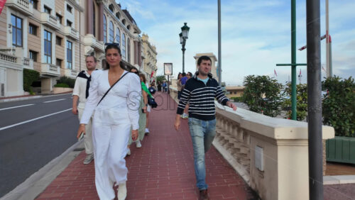 Monaco City, Monaco – July 18, 2025: Tourists and cars moving along the scenic pedestrian path by the waterfront, enjoying the Mediterranean views on a sunny day - Starpik Stock