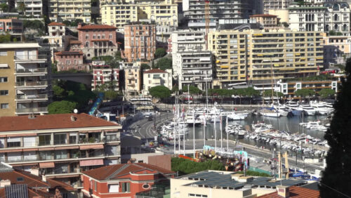 Monte Carlo, Monaco – July 4, 2025: View of buildings, high-rise towers, and bustling marina filled with luxury yachts, framed by the surrounding mountains - Starpik Stock