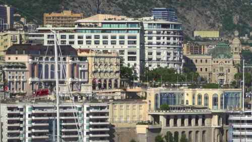 Monte Carlo, Monaco – July 4, 2025: View of buildings, high-rise towers, and bustling marina filled with luxury yachts, framed by the surrounding mountains - Starpik Stock