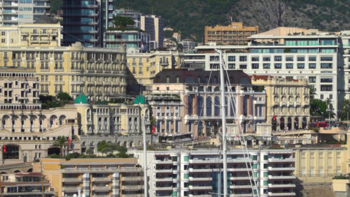 Monte Carlo, Monaco – July 4, 2025: View of buildings, high-rise towers, and bustling marina filled with luxury yachts, framed by the surrounding mountains - Starpik Stock