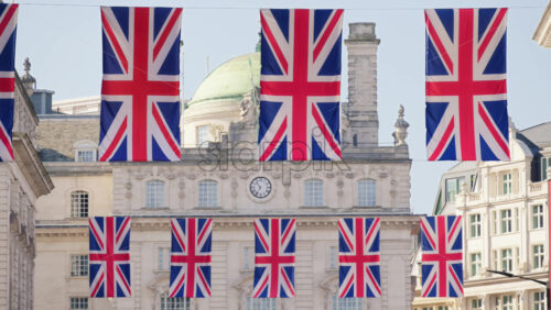 Multiple flags of the United Kingdom hanging proudly above Regent street in central London - Starpik Stock