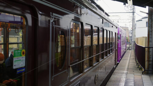 Nara, Japan – April 11, 2025: Brown tram going towards Arashiyama arriving at the station - Starpik Stock