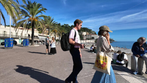 Nice, France – August 15 2025: Palm lined promenade by the beach with people walking and enjoying the sunny weather - Starpik Stock