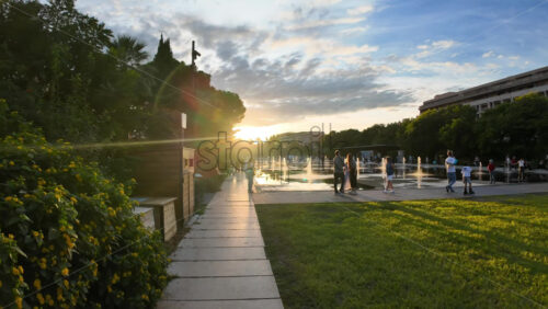 Nice, France – August 15, 2025: Sunset view of the tram with golden light reflecting on the street and people walking - Starpik Stock