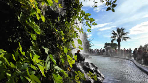 Nice, France – August 15, 2025: View of the waterfall at Castle Hill with clear water cascading down the rocks and tourists admiring the natural beauty - Starpik Stock
