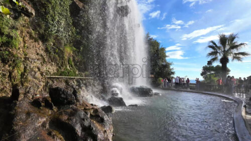 Nice, France – August 15, 2025: View of the waterfall at Castle Hill with clear water cascading down the rocks and tourists admiring the natural beauty - Starpik Stock