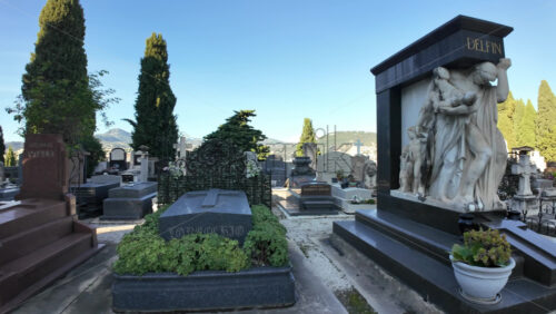 Nice, France – July 16, 2025: Peaceful cemetery with ornate marble statues, gravestones, and tall cypress trees under a clear blue sky - Starpik Stock