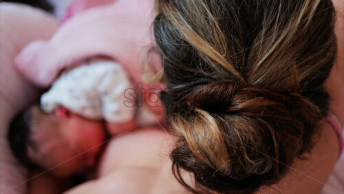Overhead shot of a mother breastfeeding her newborn baby in a quiet, nurturing environment - Starpik Stock
