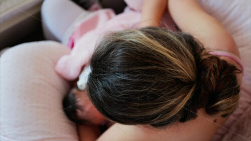 Overhead shot of a mother breastfeeding her newborn baby in a quiet, nurturing environment - Starpik Stock