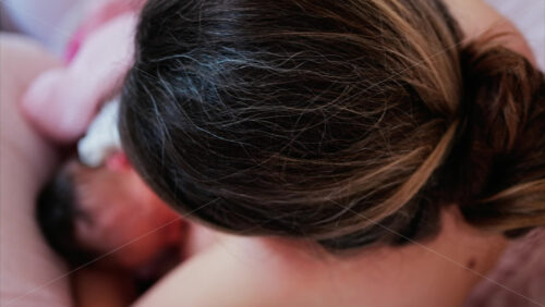 Overhead shot of a mother breastfeeding her newborn baby in a quiet, nurturing environment - Starpik Stock