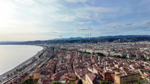 Panoramic aerial view of Nice, France, showcasing the Promenade des Anglais, the beach, and the old town with its iconic red rooftops - Starpik Stock