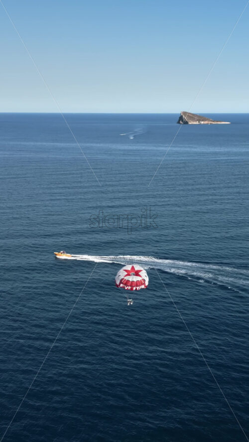 People parasailing on the Mediterranean Sea in Benidorm, Spain. Vertical - Starpik Stock