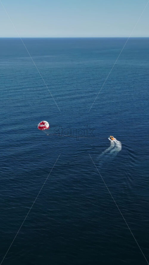 People parasailing on the Mediterranean Sea in Benidorm, Spain. Vertical - Starpik Stock