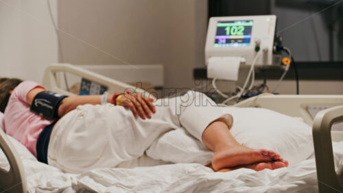 Pregnant woman lying in a hospital bed during a prenatal check-up at the doctor’s office - Starpik Stock