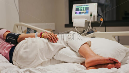 Pregnant woman lying in a hospital bed during a prenatal check-up at the doctor’s office - Starpik Stock