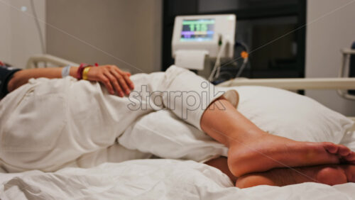 Pregnant woman lying in a hospital bed during a prenatal check-up at the doctor’s office - Starpik Stock