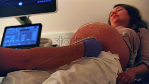 Pregnant woman undergoing an ultrasonography at a doctor’s office - Starpik Stock