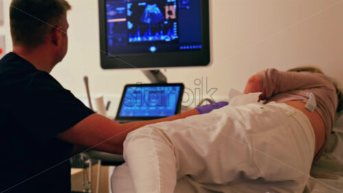 Pregnant woman undergoing an ultrasonography at a doctor’s office - Starpik Stock