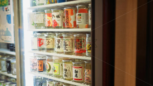 Shinjuku, Japan – April 12, 2025: Close up of different beverages in a fridge in a store on the Omoide Yokocho Memory Lane. Translation: “Beverage names and their descriptions” - Starpik Stock
