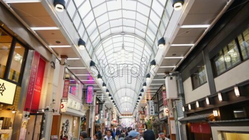 Taito, Japan – April 13. 2025: People walking through the Asakusa, Kannon Dori Market in daylight. Translation: “Store names” - Starpik Stock