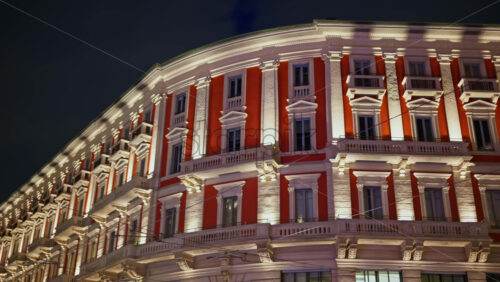 Tall red and white building in the Saint Ambrogio Square in Milan, Italy in the evening - Starpik Stock