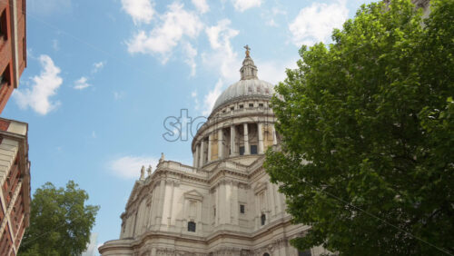 The Dome of St. Paul’s Cathedral rising above the trees with a clear blue sky in the background in London, England - Starpik Stock