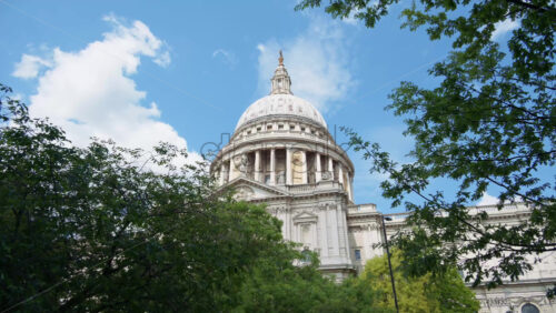 The Dome of St. Paul’s Cathedral rising above the trees with a clear blue sky in the background in London, England - Starpik Stock