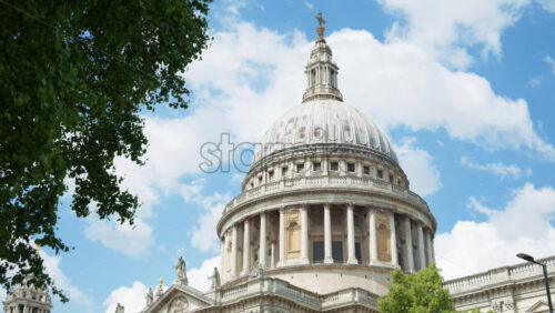 The Dome of St. Paul’s Cathedral rising above the trees with a clear blue sky in the background in London, England - Starpik Stock