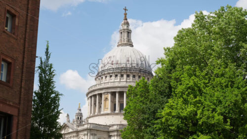 The Dome of St. Paul’s Cathedral rising above the trees with a clear blue sky in the background in London, England - Starpik Stock