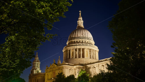 The Dome of St. Paul’s Cathedral rising above the trees with the night sky in the background in London, England - Starpik Stock